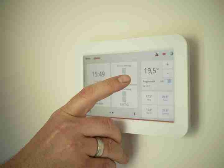 man adjusting his thermostat